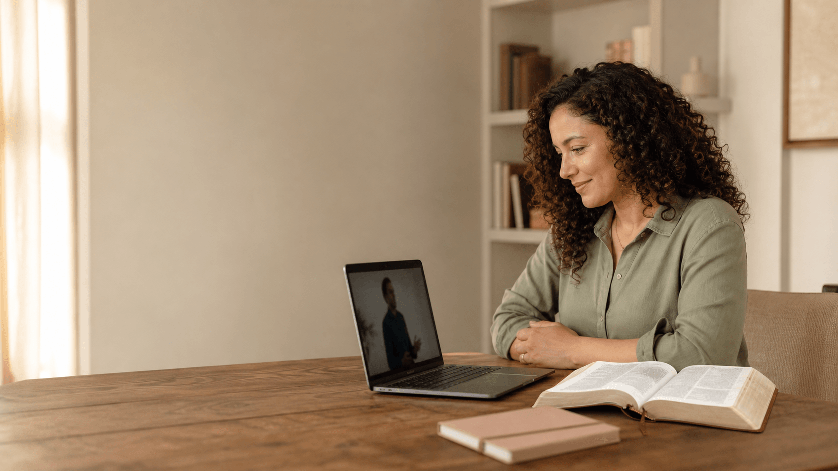 A woman watching a short video devotional beside an open Bible